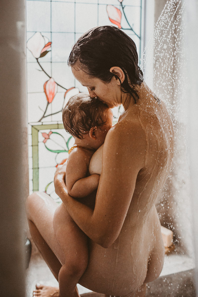 mother kisses toddler in shower